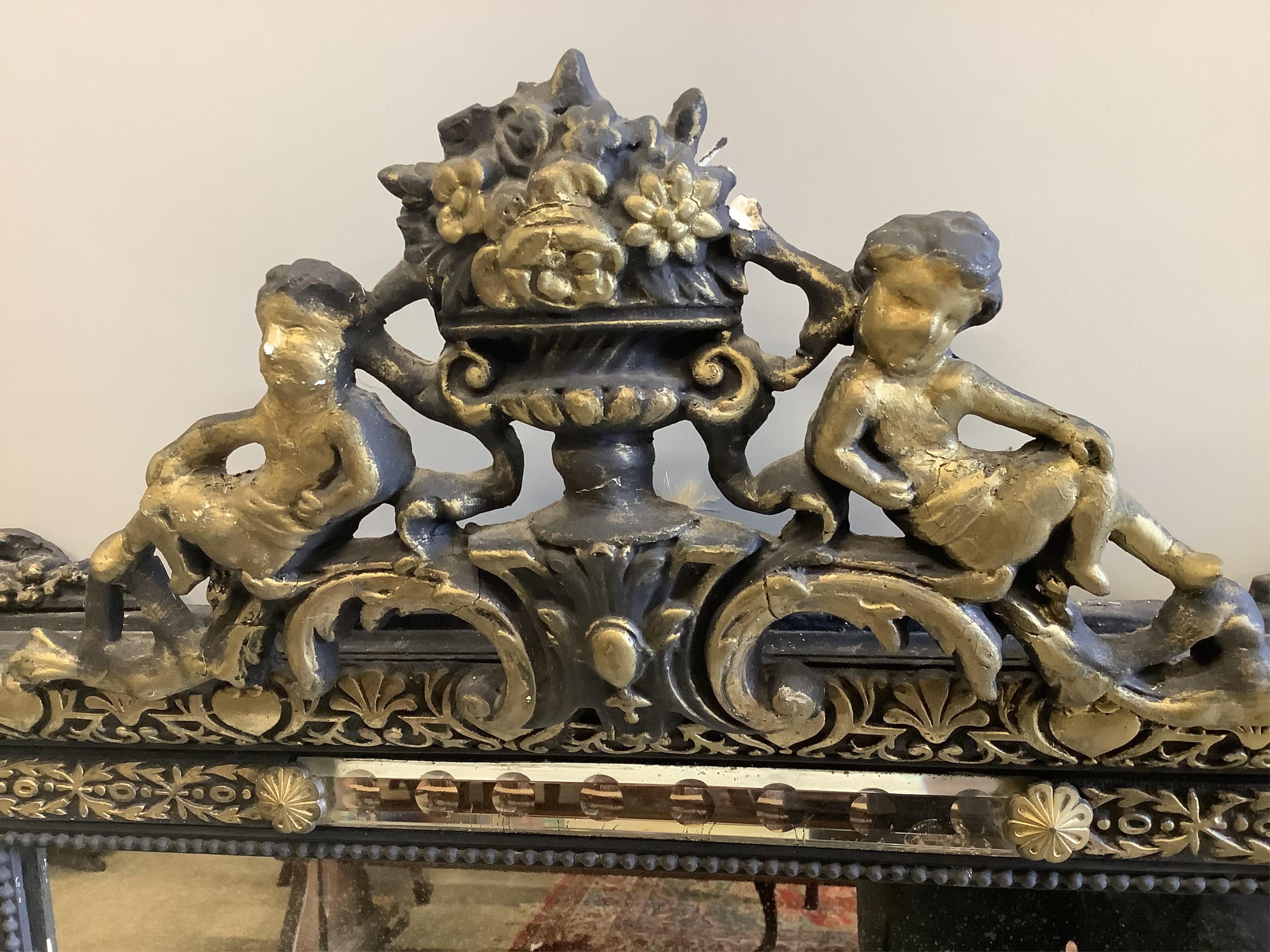A French decorative wall mirror with cherub motifs, (later painted), width 81cm, height 127cm. Condition - poor